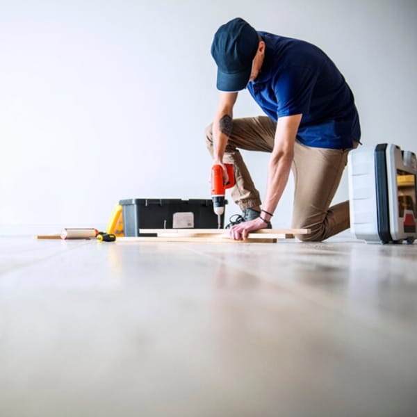 Montaje de madera con taladro durante reforma en vivienda. Colocación de suelos